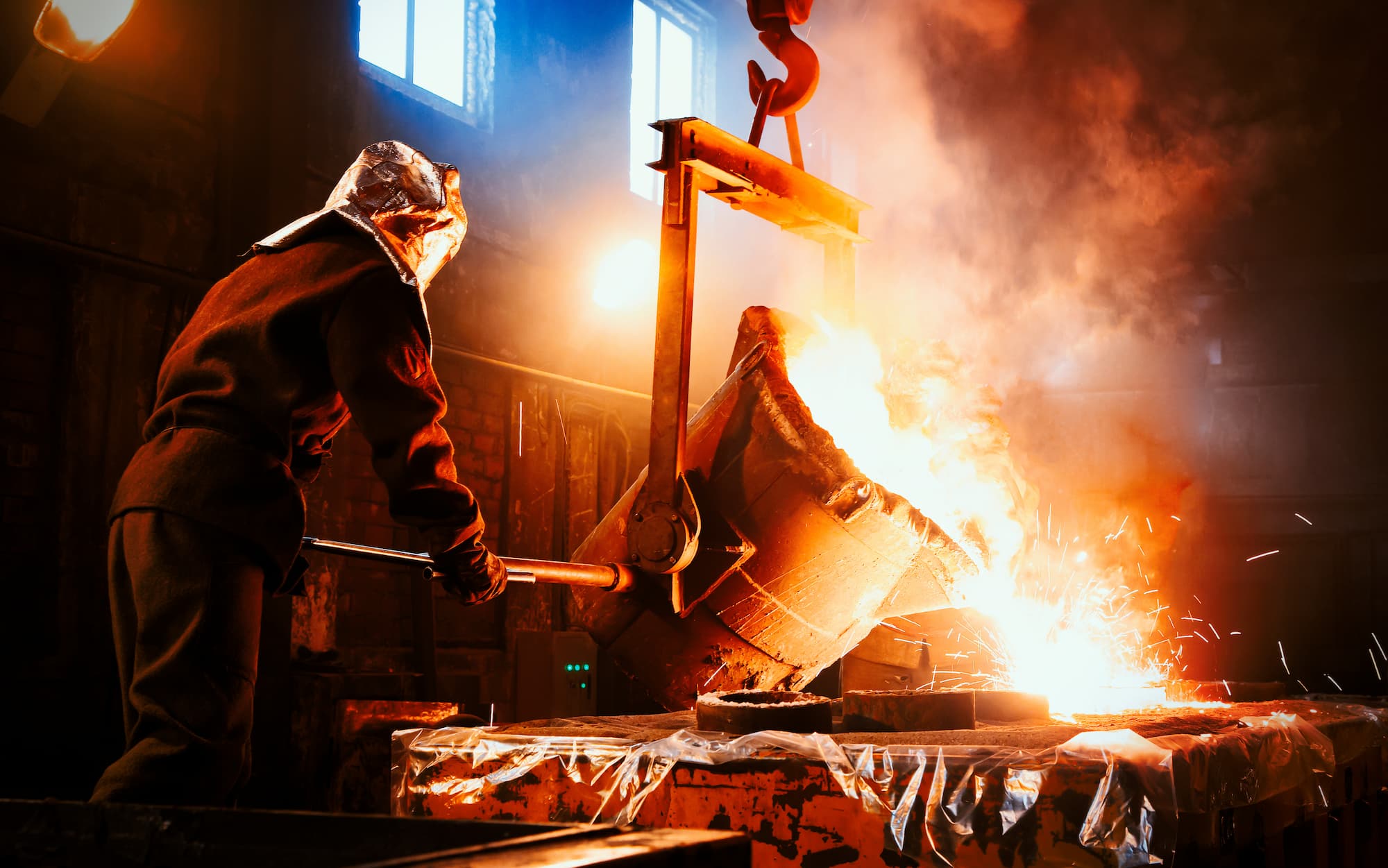 Engineer pouring molten metal. 
